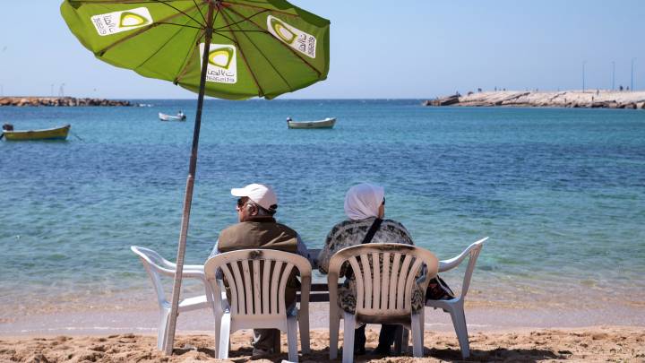 زوجين مسنين يسترخون على شاطئ جليم