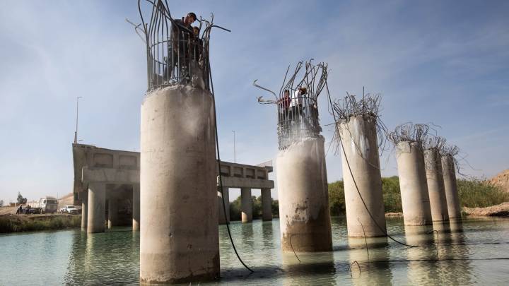 Men repair a bridge near Mosul, Iraq. 