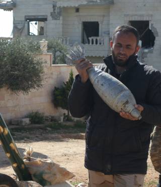 مقاتلين ينقلون القذائف