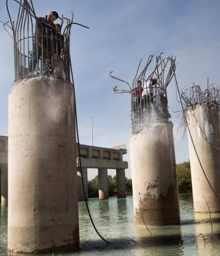 Men repair a bridge near Mosul, Iraq. 
