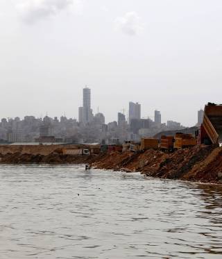 Trucks dump earth and trash into the sea as part of the land reclamation process at the Bourj Hammond landfill in Beirut. 